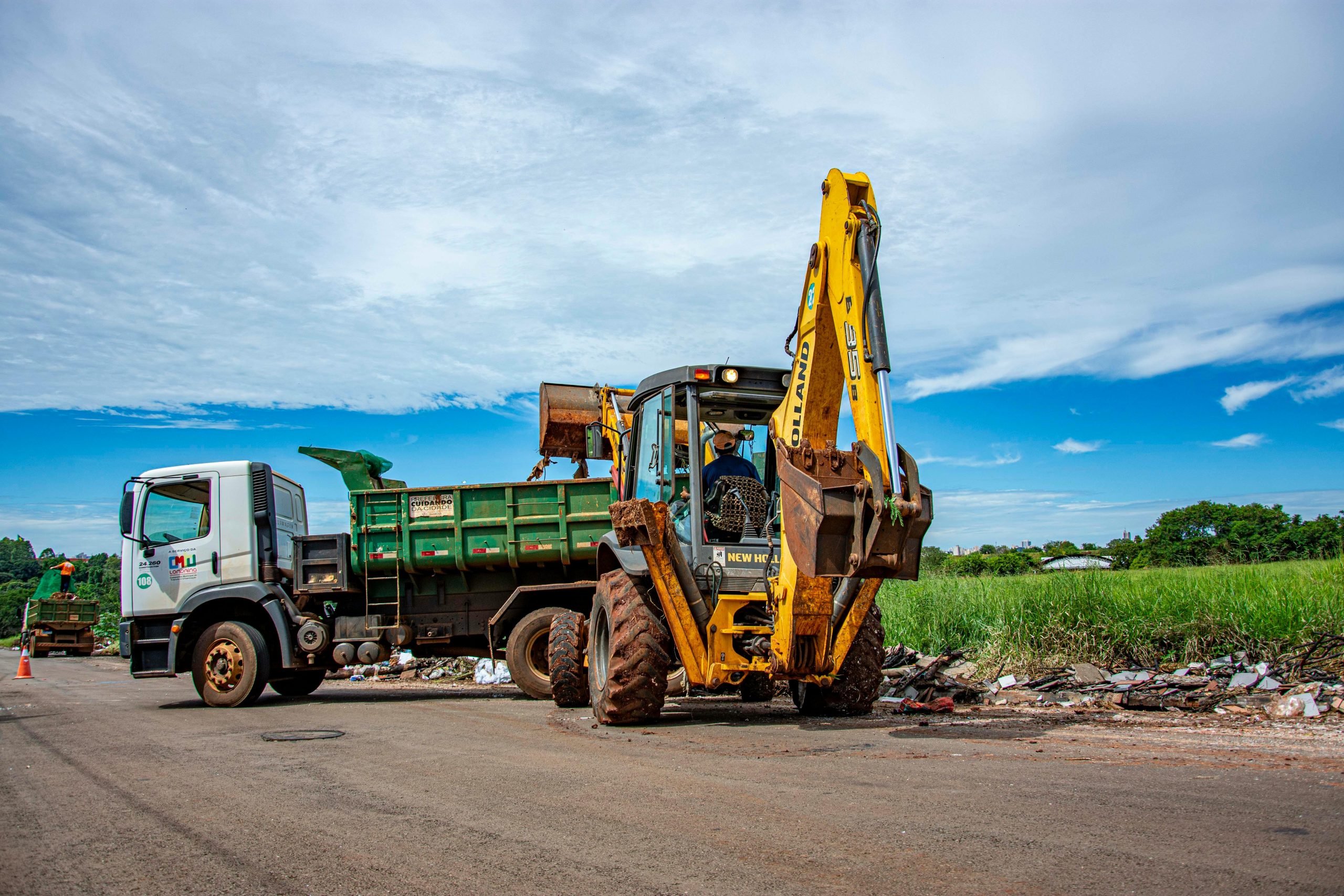 Excavator and truck clearing rubble in Londrina, Brazil outdoors.